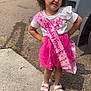 child, birthday, princess, pink, crown, sash, outdoor, sidewalk, vehicle, curly_hair, sandals, toddler, celebration, smile, pose, sunny, concrete, dress, white_shirt, happy