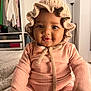 baby, child, infant, knit_bonnet, pink_outfit, smiling, face, indoor, lamp, wardrobe, clothing, furniture, portrait, cute, seated, soft_lighting, cozy, home, person, young_child