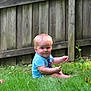 Rex is registered to the contest to win money with this photo: child, toddler, blonde_hair, grass, outdoor, fence, blue_shirt, sitting, smile, nature, greenery, baby, cute, portrait, summer, playful, sunlight, yard, person, casual
