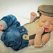 Damauri is registered to the contest to win money with this photo: baby, newborn, sleeping, denim, cap, clothing, bare_chest, soft_surface, cute, infant, footwear_absent, relaxed, portrait, child, small_hands, peaceful, indoor, fashion, photography, adorable
