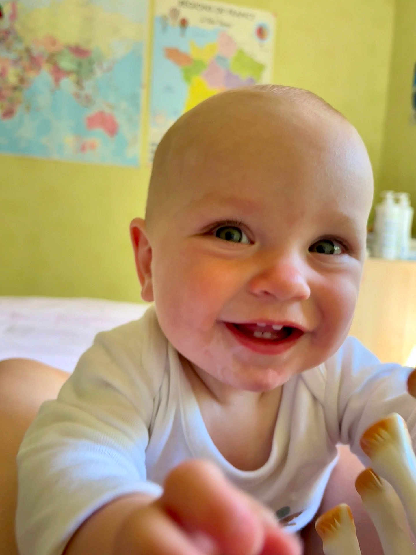 Félix participe au concours pour gagner de l'argent avec cette photo : baby, child, smiling, happy, face, teeth, eyes, white_clothing, indoor, map, wall, room, person, portrait, cute, infant, hand, reaching, closeup, head