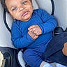 Eleven is registered to the contest to win money with this photo: baby, child, car_seat, blue_clothing, hands_clasped, socks, infant, sunscreen, warning_label, portrait, cute, indoors, seatbelt, smiling, young_child, cozy, comfort, person, human, closeup