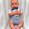 Briar joined the competition — help win amazing prizes! baby, infant, child, blue_bow_tie, striped_romper, suspenders, knitted_blanket, white_background, cute, portrait, sitting, hands_clasped, looking_at_camera, indoor, soft_lighting, small_feet, curious_expression, adorable, young_child, face