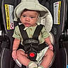 baby, child, car_seat, seatbelt, hat, striped, green_clothing, socks, infant, serious_expression, safety, child_safety, indoor, portrait, cute, young_child, baby_boy, car_seat_warning, clothing, headwear