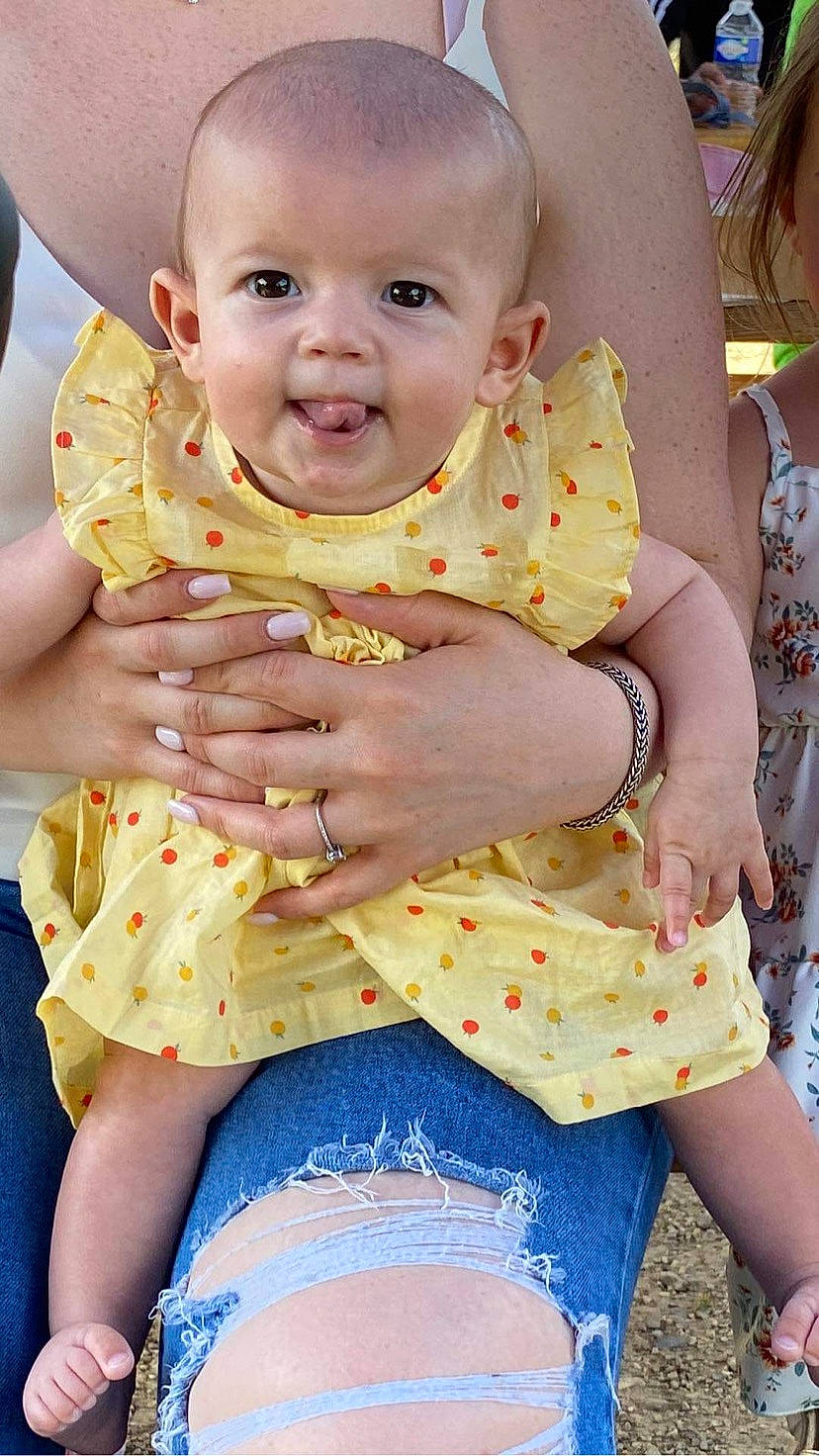 élizéa participe au concours pour gagner de l'argent avec cette photo : abdomen, baby, baby_toddler_clothing, cheek, child, event, fun, gesture, grass, happy, human_leg, person, pink, sitting, skin, summer, thigh, toddler, trunk, waist