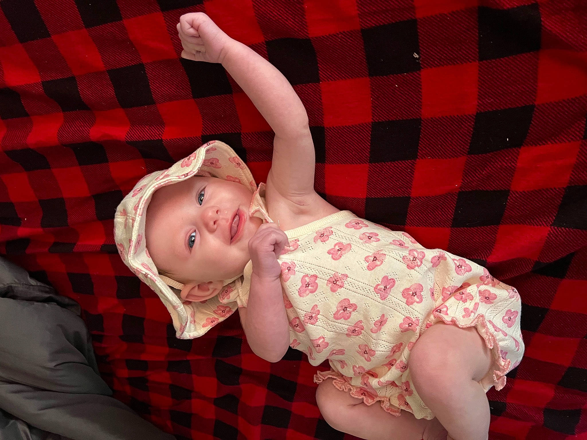 Everleigh is registered to the contest to win money with this photo: baby, baby_toddler_clothing, child, comfort, elbow, eye, finger, gesture, happy, headwear, linens, pattern, person, pink, plaid, red, skin, sleeve, smile, tartan