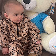 Stanyslas a rejoint le concours — aidez-le/la à gagner de superbes lots ! baby, teddy_bear, plush_toy, couch, child, indoor, clothing, footwear, soft_toy, cute, sitting, portrait, furniture, room, comfort, toy, childhood, smiling, face, cozy
