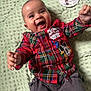 baby, smiling, child, infant, plaid_shirt, mickey_mouse, milestone_card, 5_months, happy, lying_down, blanket, clothing, cute, portrait, indoors, toddler, person, face, joy, celebration