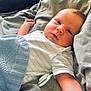 baby, infant, pacifier, blanket, bed, sheet, gray, blue, knitted, sleepwear, lying_down, arm, face, skin, indoor, cute, child, resting, cozy, soft