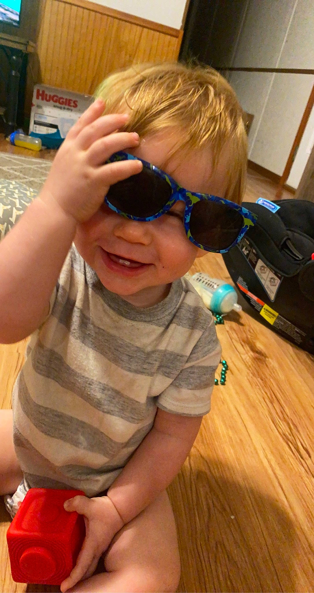 Kase is registered to the contest to win money with this photo: child, cool, eye_glass_accessory, eyewear, facial_expression, finger, flooring, fun, glasses, goggles, happy, hardwood, joy, person, personal_protective_equipment, play, smile, sunglasses, thumb, toddler