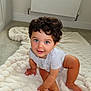 toddler, child, baby, curly_hair, blue_eyes, crawling, blanket, carpet, indoors, smiling, cute, happy, person, skin, foot, hand, head, room, radiator, clothing