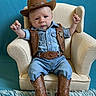 Wyatt joined the competition — help win amazing prizes! baby, child, cowboy, hat, vest, belt, boots, denim, chair, armchair, blue_background, carpet, portrait, cute, fashion, western, infant, smile, indoors, costume