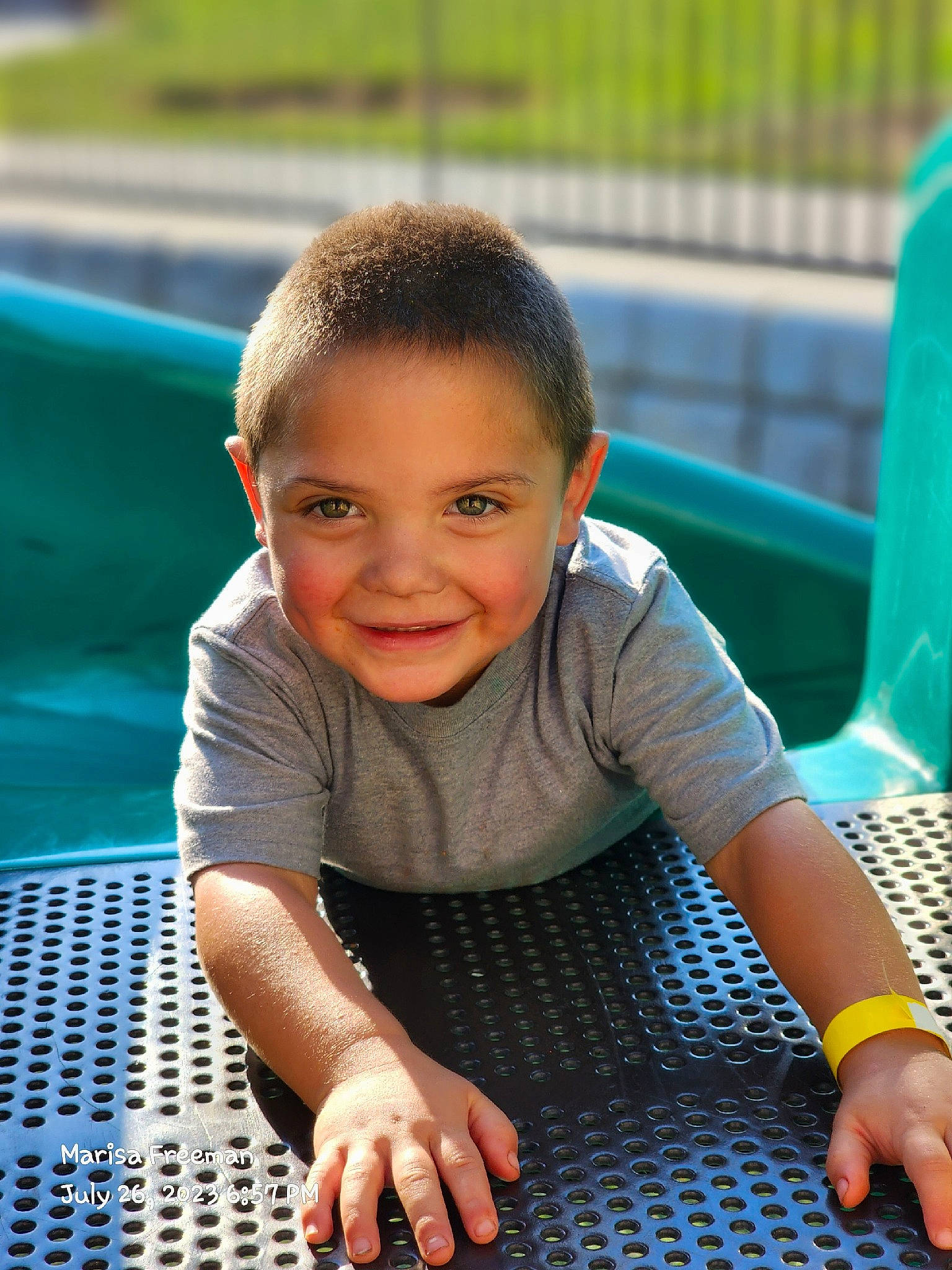 Dexter is registered to the contest to win money with this photo: baby_toddler_clothing, blue, child, city, flooring, fun, grass, green, happy, joy, leisure, outdoor_play_equipment, pattern, person, play, recreation, sitting, skin, smile, thumb