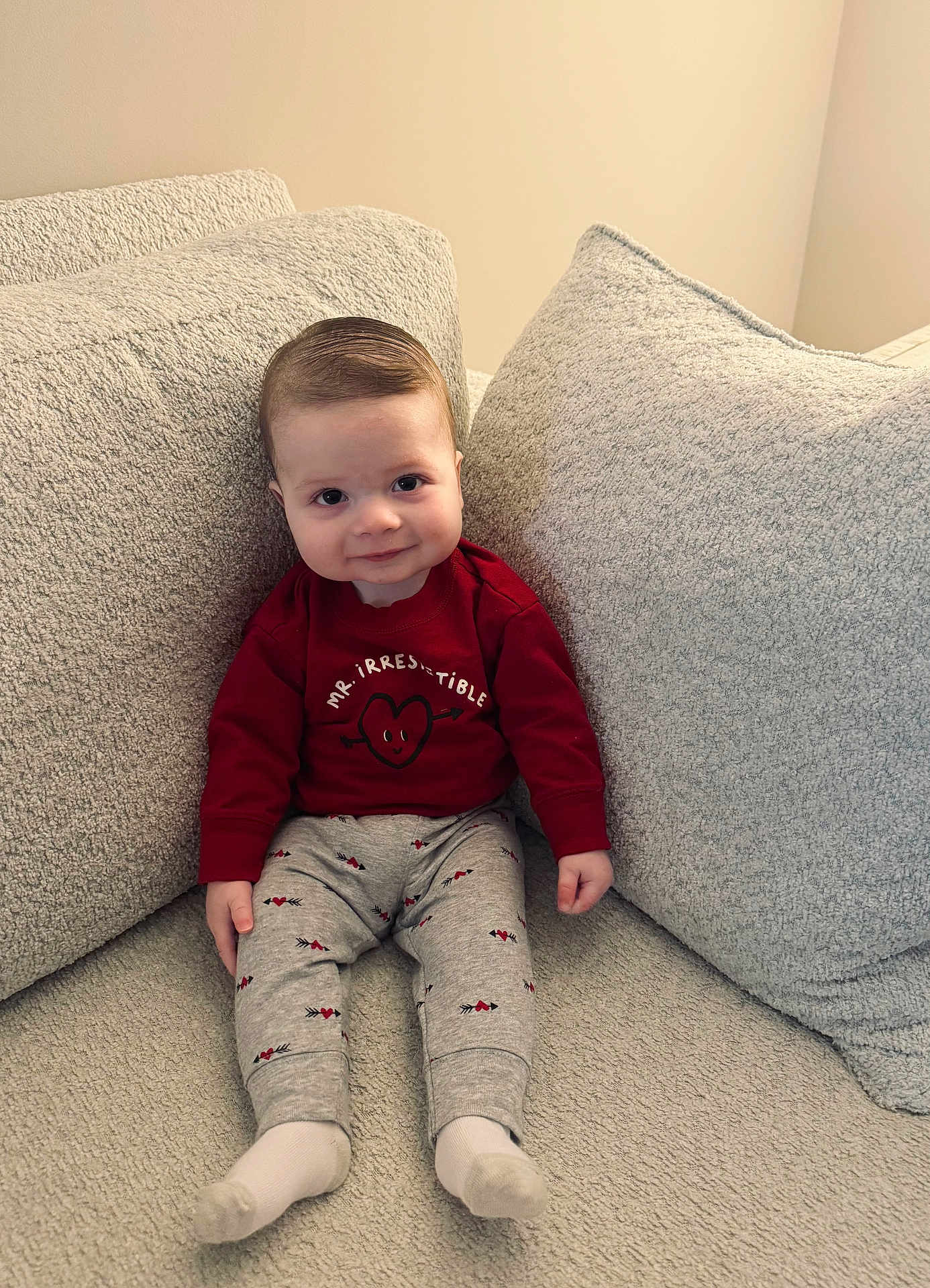 Blake joined the competition — help win amazing prizes! baby, infant, child, couch, pillow, sweater, pants, socks, smile, face, eyes, hair, sitting, living_room, cozy, textile, pattern, adorable, portrait, indoor