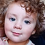child, toddler, curly_hair, blue_eyes, face, portrait, smile, striped_shirt, casual_clothing, indoor, cute, young_child, person, closeup, baby, innocent, soft_light, headshot, happy, skin