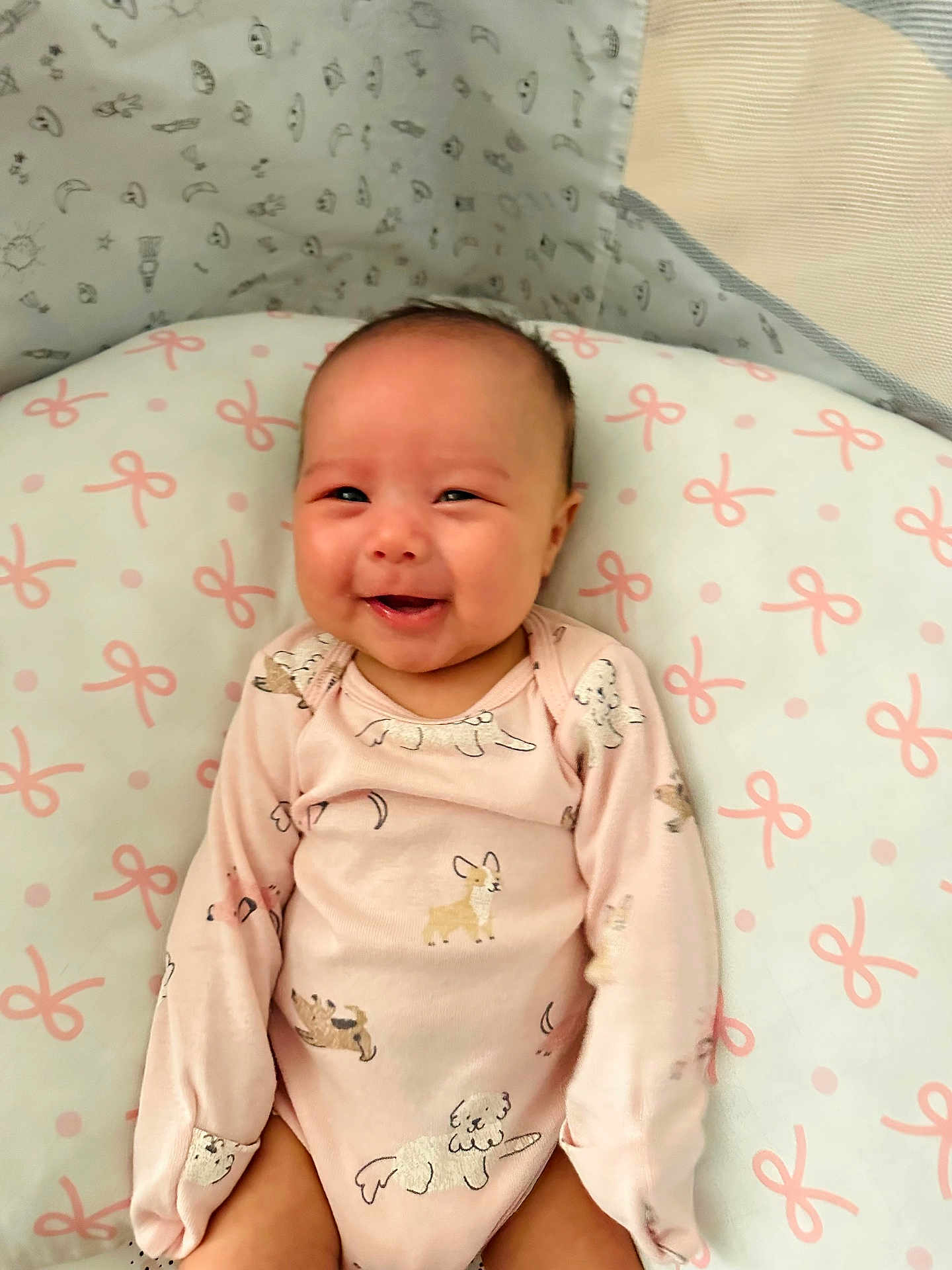 Lillianna joined the competition — help win amazing prizes! baby, smiling, infant, onesie, pink_clothing, dog_pattern, cushion, pink_bows, lying_down, happy, child, face, cute, soft_lighting, indoors, adorable, young_child, baby_girl, comfort, portrait