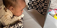Lillianna is registered to the contest to win money with this photo: baby, black_and_white, blanket, book, child, clothing, curious, fish, floor, focus, furniture, head, home, indoor, infant, pattern, play_mat, soft, toy, tummy_time