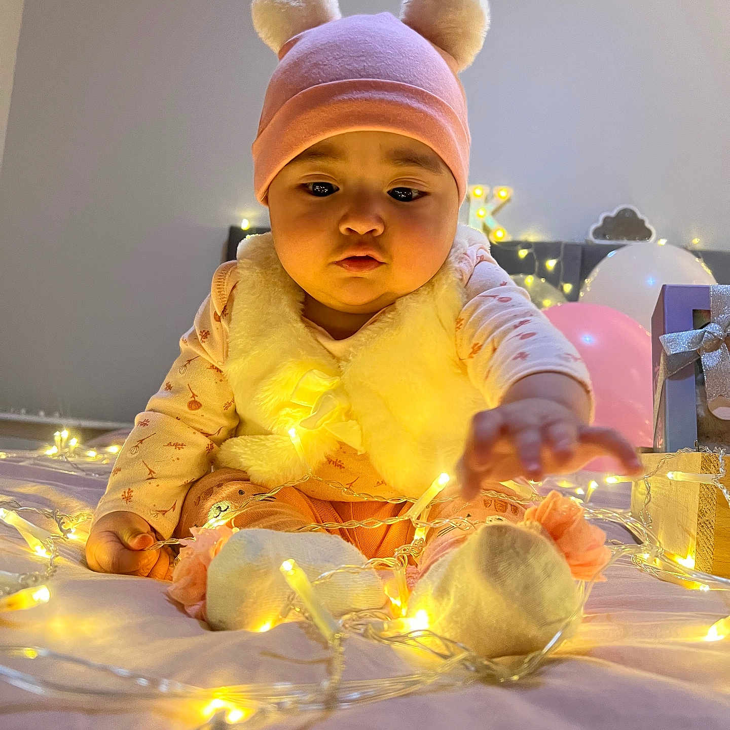 Evelyn Isabella is registered to the contest to win money with this photo: baby, balloon, beanie, bodypart, bonnet, candle, cap, clothing, face, festival, finger, hand, hat, head, lighting, person, photography, portrait, sitting, toy
