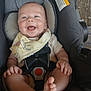 baby, car_seat, smiling, feet, bib, happy, child, infant, sitting, clothing, straps, wooden_floor, cute, young_child, person, indoor, seat, protection, secure, joyful