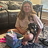Minnie joined the competition — help win amazing prizes! person, dog, indoor, rug, basket, sandal, leather_couch, window_blinds, glasses, smile, casual, sitting, toy, home, floor, light, furniture, pet, happy, young