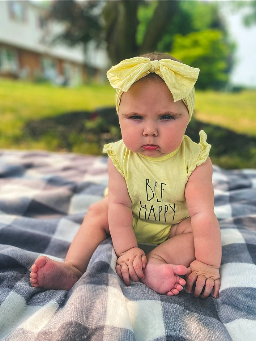 Adalynn is registered to the contest to win money with this photo: baby, baby_toddler_clothing, cap, child, fashion_accessory, flash_photography, fun, grass, happy, headpiece, headwear, leisure, pattern, people_in_nature, person, plant, portrait_photography, recreation, sitting, toddler