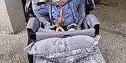 Olanto participe au concours pour gagner de l'argent avec cette photo : baby, stroller, pacifier, blanket, clothing, child, infant, person, outdoor, curious, cute, hat, comfort, seat, wheel, floor, gray, black, blue, expression