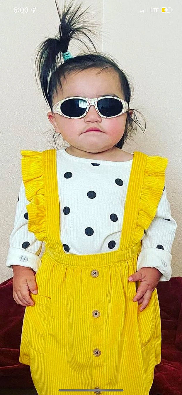 Clarissa is registered to the contest to win money with this photo: baby_toddler_clothing, bow_tie, child, collar, day_dress, eye, eyewear, face, fashion_design, goggles, hairstyle, head, neck, one_piece_garment, pattern, person, sleeve, sunglasses, t_shirt, vision_care