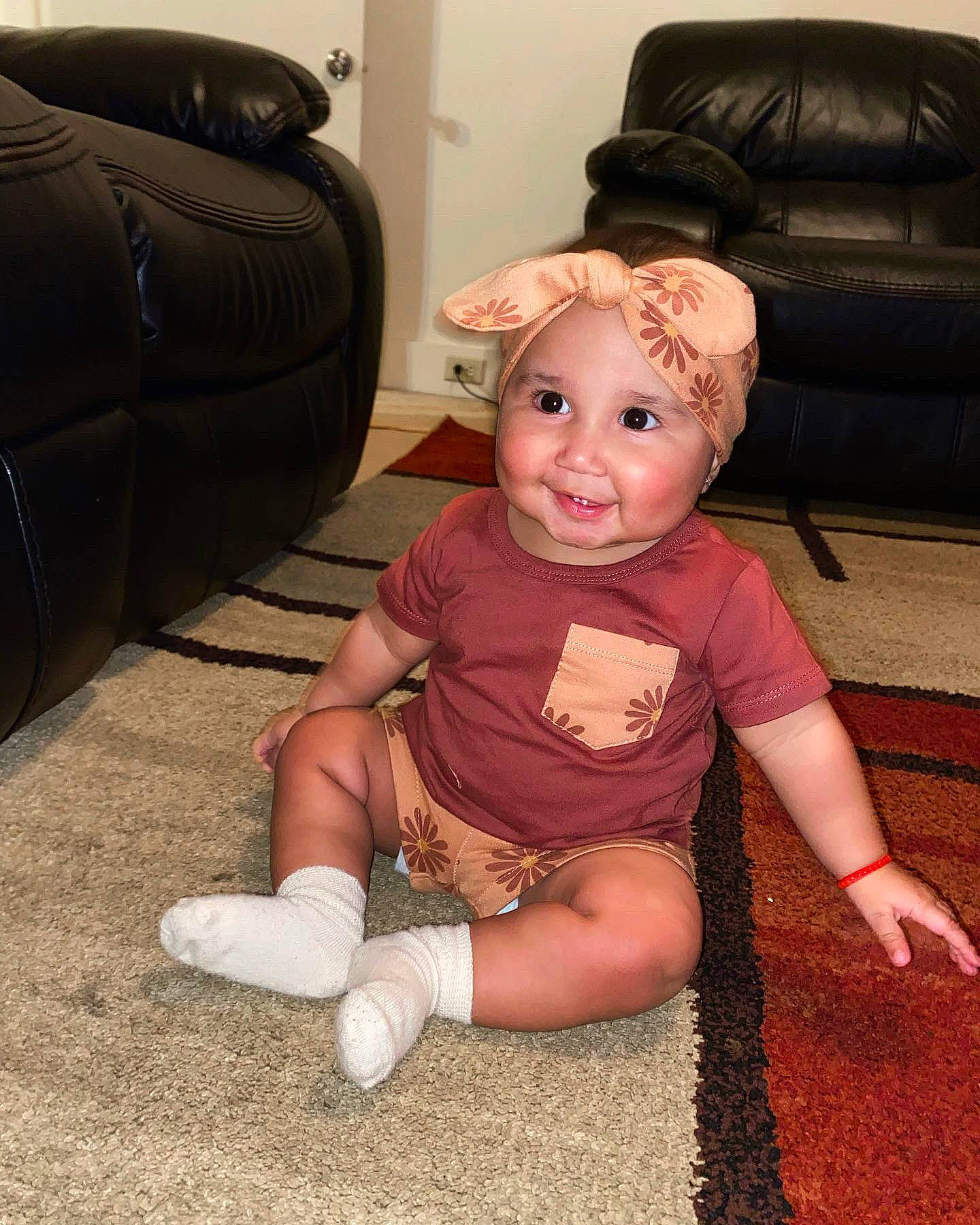 Analia is registered to the contest to win money with this photo: baby, baby_toddler_clothing, cheek, child, comfort, finger, floor, flooring, foot, fun, hardwood, headwear, human_leg, joint, joy, person, sitting, skin, smile, textile