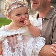 Roxane participe au concours pour gagner de l'argent avec cette photo : adult, baby, celebration, child, closeup, cute, family, greenery, happy, headband, holding, joy, lace_dress, man, outdoor, people, person, portrait, smiling, toddler