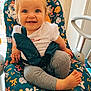 baby_seat, blue_eyes, child, childrens_furniture, curly_hair, cute, daylight, foot, grey_pants, happy, home_interior, indoor, natural_light, patterned_fabric, playful, sitting, smiling, toddler, white_shirt, window