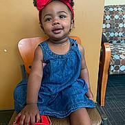 Dior is registered to the contest to win money with this photo: carpet, casual, chair, child, cute, denim_dress, furniture, happy, headband, indoor, patterned_chair, person, playful, portrait, red_bow, shoe, sitting, smiling, toddler, young_child