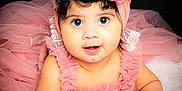 Leia joined the competition — help win amazing prizes! baby, infant, tutu, headband, flower, pink, dress, curly_hair, blue_eyes, soft_blanket, portrait, cute, child, smiling, indoor, studio_lighting, close_up, crawling, happy, person
