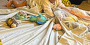Mahratie is registered to the contest to win money with this photo: baby, blanket, car_seat, toy, carpet, indoor, child, infant, face, person, soft_toy, pink, blue, yellow, green, floor, cute, playtime, expression, laying