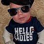 James joined the competition — help win amazing prizes! baby, infant, sunglasses, hat, cap, mittens, onesie, tshirt_text, hello_ladies, pillow, patterned_pillow, indoor, portrait, cute, smile, baby_clothes, baby_pants, arrows_pattern, flash_reflection, fashion_accessory