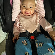 Makayla joined the competition — help win amazing prizes! baby, child, car_seat, pink_headband, bib, smile, happy, denim_jeans, minnie_mouse, clothing, infant, seatbelt, cute, portrait, indoors, person, headwear, fashion, baby_care, seat