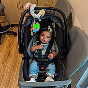 Island joined the competition — help win amazing prizes! baby, child, car_seat, denim_overalls, headband, toy, indoor, wooden_floor, chair, cabinet, flooring, baby_clothes, seat_belt, infant, cute, child_seat, room, baby_toy, sitting, calm