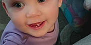 Miranda joined the competition — help win amazing prizes! baby, child, smile, face, hand, teeth, purple_shirt, indoor, toy_storage, curious, bright_eyes, close_up, infant, young_child, candid, happy, person, skin, fingertips, background