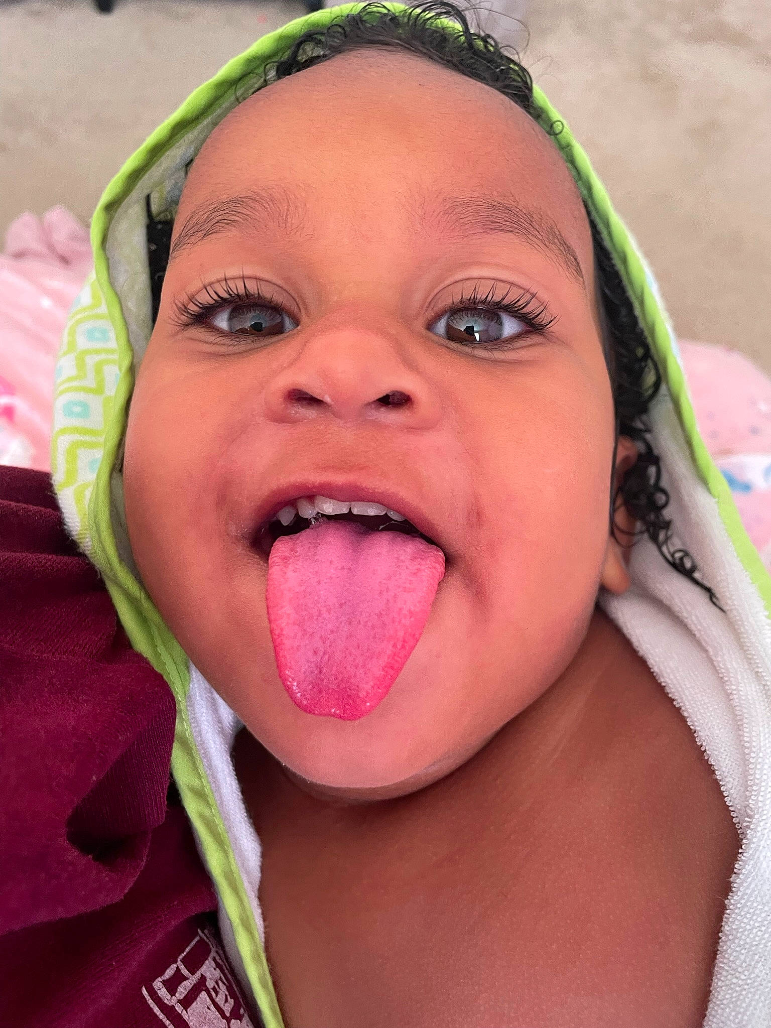 Reina is registered to the contest to win money with this photo: cheek, child, close_up, eyelash, facial_expression, fun, grass, happy, jaw, leisure, lip, mouth, nose, people_in_nature, person, pink, skin, smile, toddler, tongue