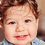toddler, child, smiling, face, curly_hair, brown_eyes, bib, mickey_mouse, clothing, portrait, cute, happy, indoors, baby, infant, closeup, person, young_child, expression, soft_background