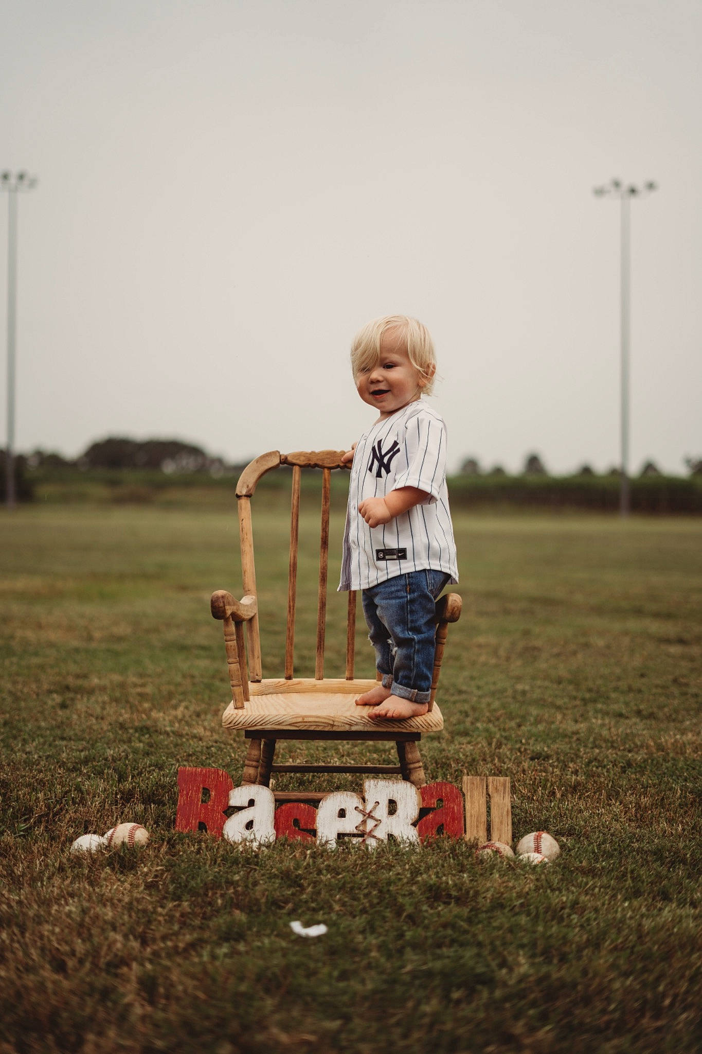 Brexton is registered to the contest to win money with this photo: child, flash_photography, fun, grass, grassland, happy, landscape, lawn, people_in_nature, person, recreation, rural_area, sky, standing, t_shirt, tire, toddler, tree, wheel, wheelbarrow