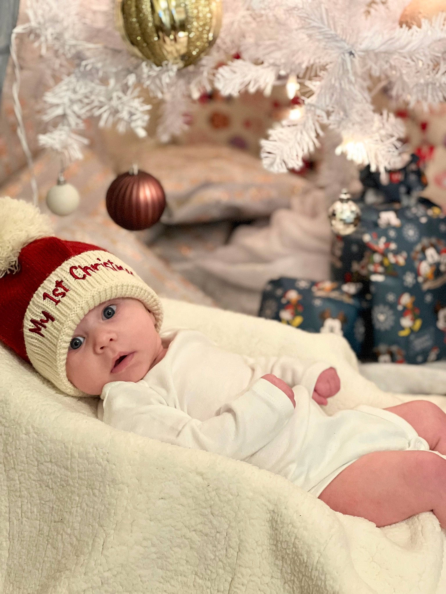 Zayden is registered to the contest to win money with this photo: baby, baby_sleeping, baby_toddler_clothing, cap, child, christmas, christmas_decoration, christmas_ornament, comfort, event, happy, headwear, holiday, knit_cap, linens, ornament, person, plant, room, textile