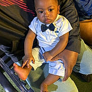 Isaiah joined the competition — help win amazing prizes! baby, child, infant, portrait, sitting, formal_clothing, bow_tie, white_shirt, shorts, adult, lap, piano, keyboard, chair, indoor, photography, looking_at_camera, serious_expression, family, cozy