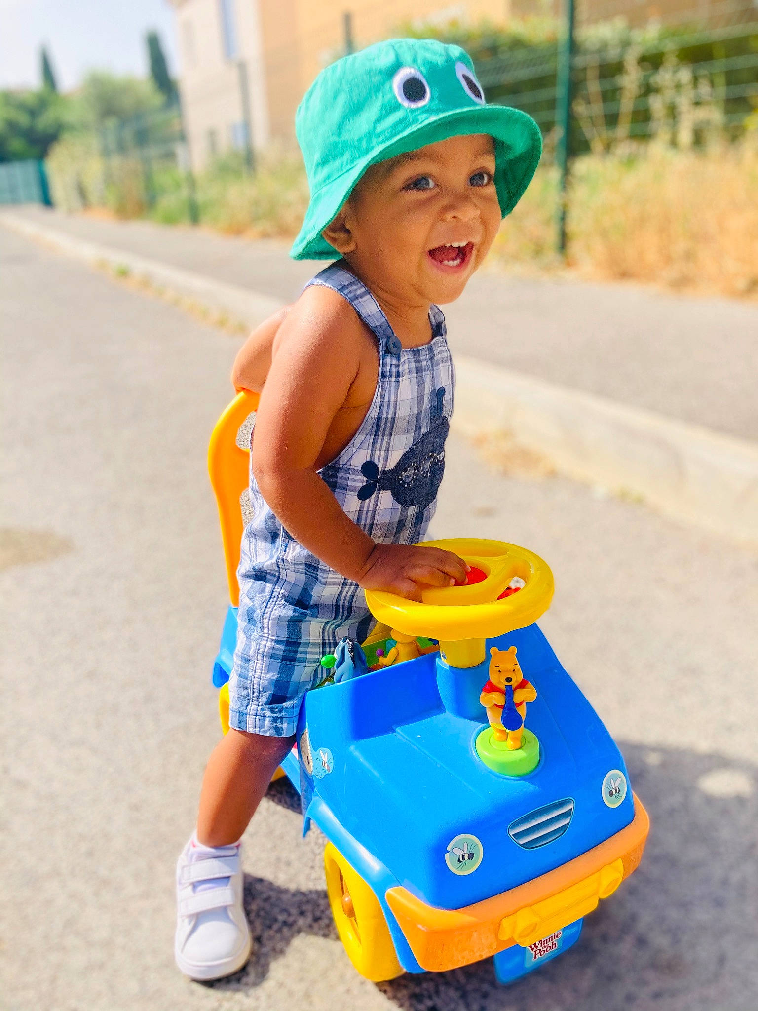 Maëlan a rejoint le concours — aidez-le/la à gagner de superbes lots ! baby_playing_with_toys, baby_toddler_clothing, baseball_cap, cap, child, electric_blue, fun, happy, headwear, leisure, person, photograph, plant, recreation, riding_toy, shorts, smile, tire, toddler, toy