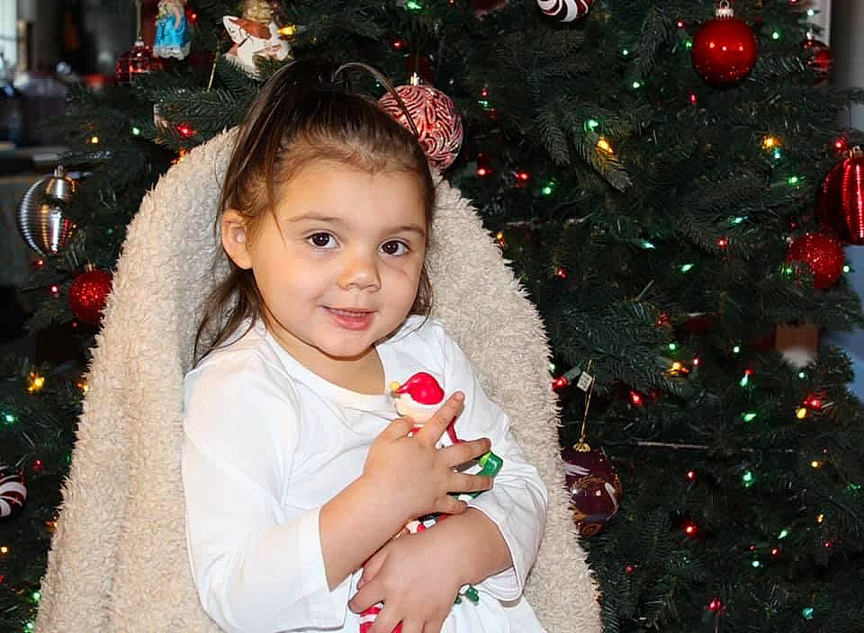 Ava joined the competition — help win amazing prizes! cheek, christmas_ornament, christmas_tree, eye, face, facial_expression, green, happy, head, holiday_ornament, human_body, iris, joy, organ, person, photograph, plant, red, smile, standing