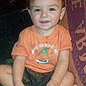 baby, blanket, camo_shorts, child, couch, cute, decor, feet, furniture, hands, happy, home, indoor, orange_tshirt, person, portrait, sitting, smiling, toddler, young_child