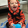 Maxton is registered to the contest to win money with this photo: baby, child, hoodie, pumpkin, halloween, orange, black, sippy_cup, blue, blanket, crocheted, floor, smiling, happy, sitting, indoors, clothing, cute, playful, person