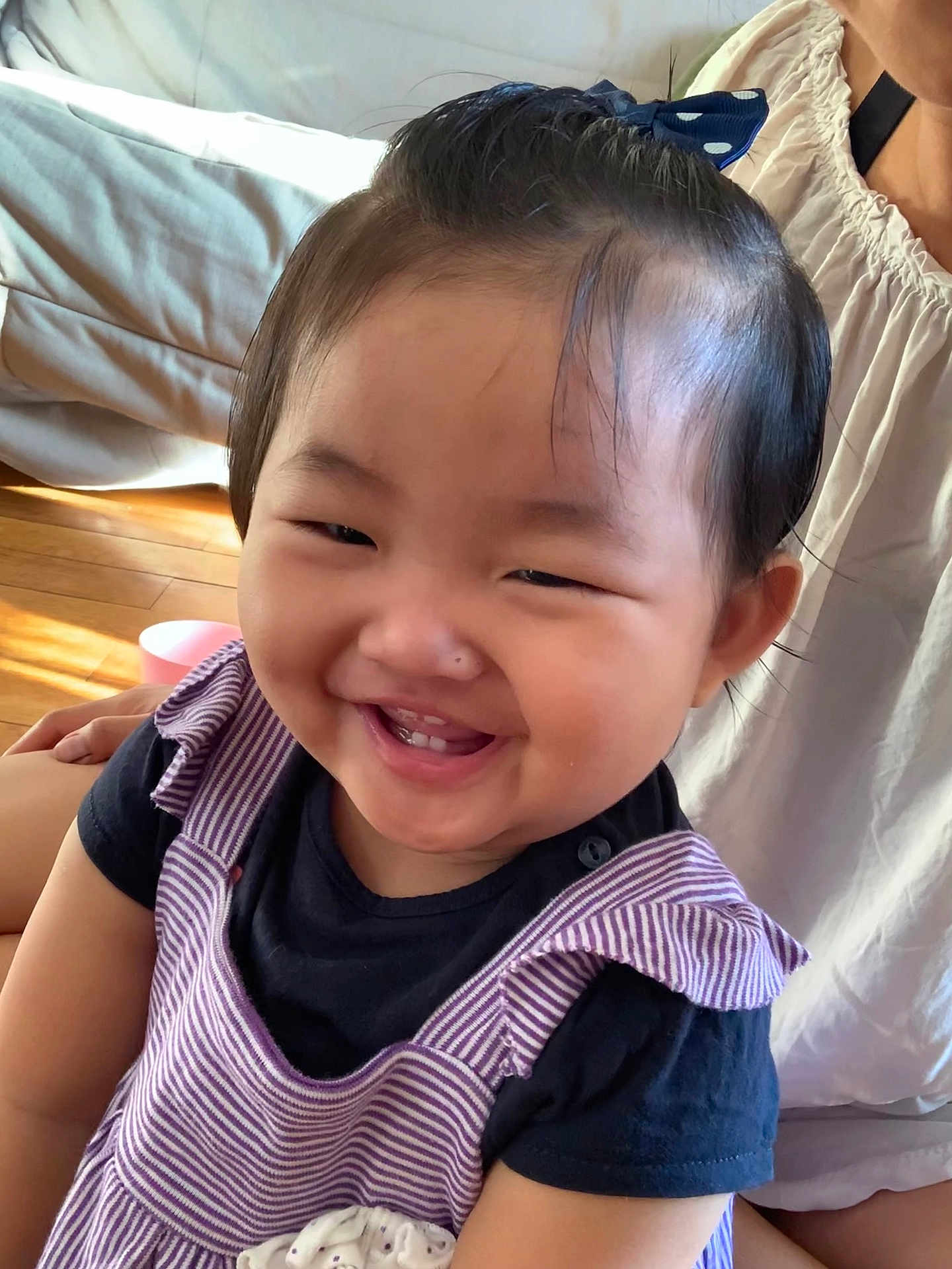 Joanna Yi a rejoint le concours — aidez-le/la à gagner de superbes lots ! toddler, child, smile, happy, face, hair_bow, striped_dress, black_shirt, indoor, wooden_floor, sunlight, person, portrait, cute, dimples, sitting, clothing, childrens_fashion, infant, young_child