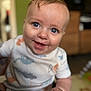 baby, smiling, blue_eyes, onesie, dinosaur_pattern, close_up, infant, happy, child, cute, chubby_hand, indoor, portrait, soft_focus, skin, expression, person, face, young_child, casual