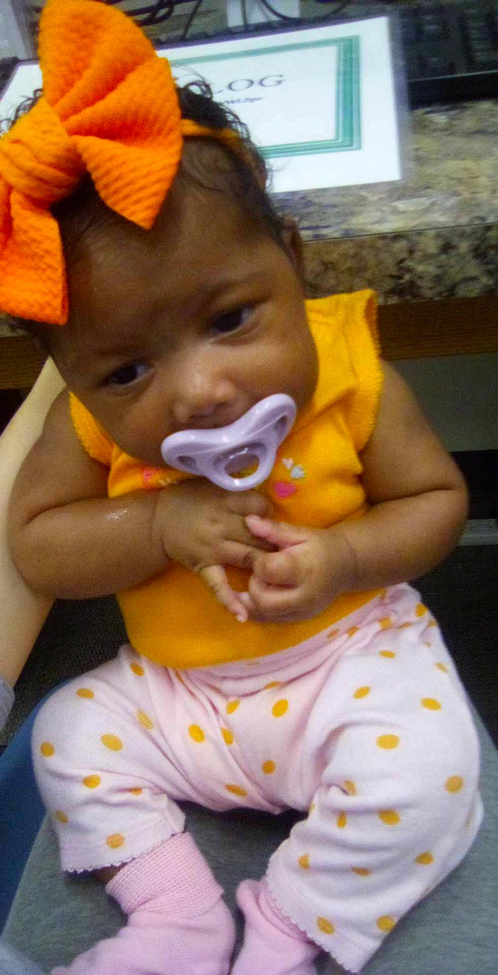 Kaia is registered to the contest to win money with this photo: baby, baby_toddler_clothing, chair, cheek, child, drinkware, ear, eyelash, finger, fun, hand, happy, iris, lip, mouth, nail, neck, nose, person, skin