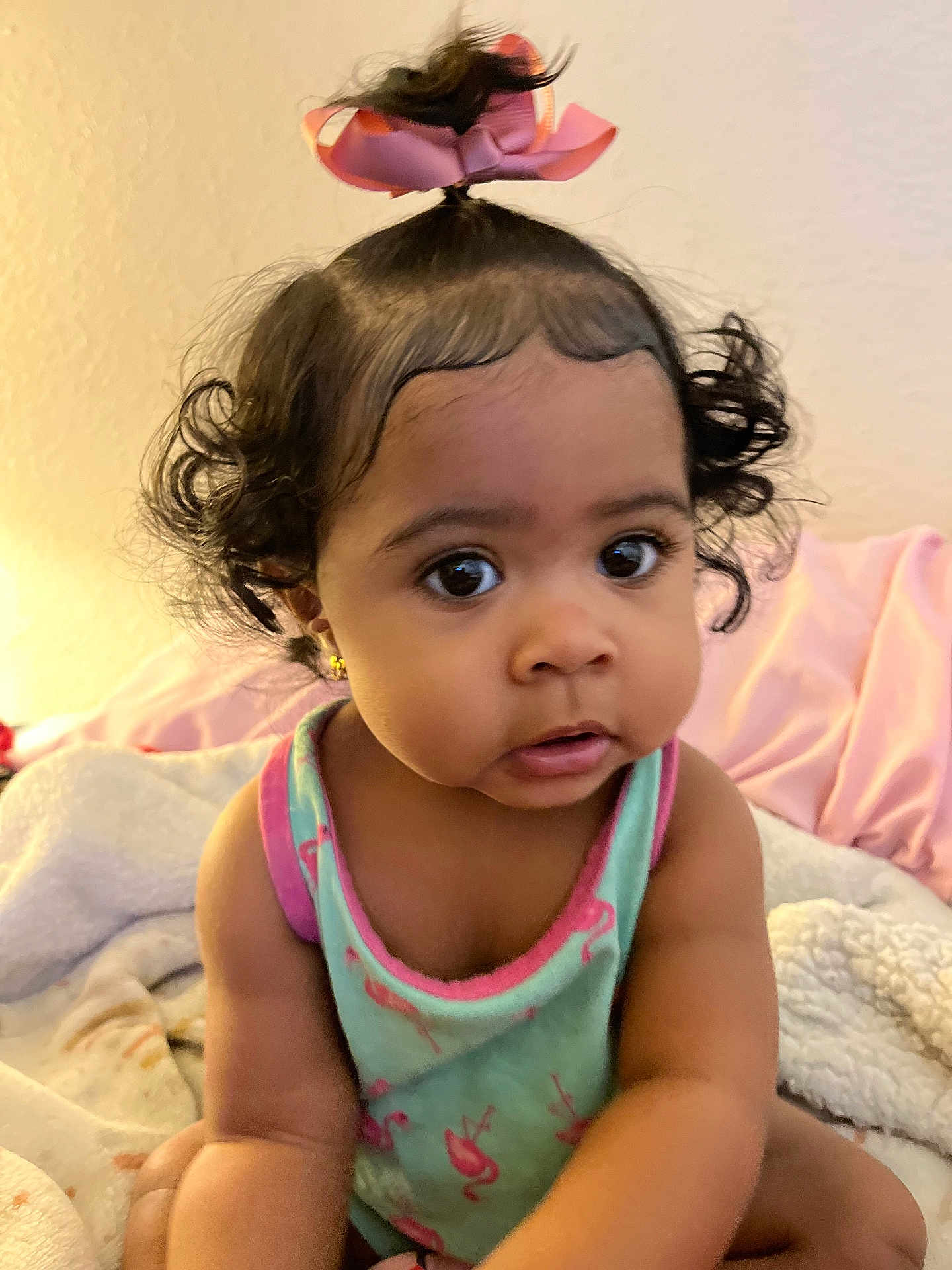 Maraya joined the competition — help win amazing prizes! toddler, child, baby, curly_hair, pink_bow, tank_top, blanket, indoor, portrait, cute, expression, sitting, clothing, face, skin, person, young_child, home, curious, cozy